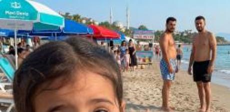 Kızım plaj elbisemi hafifçe çekiştirip kulağıma fısıldadı: “Anne